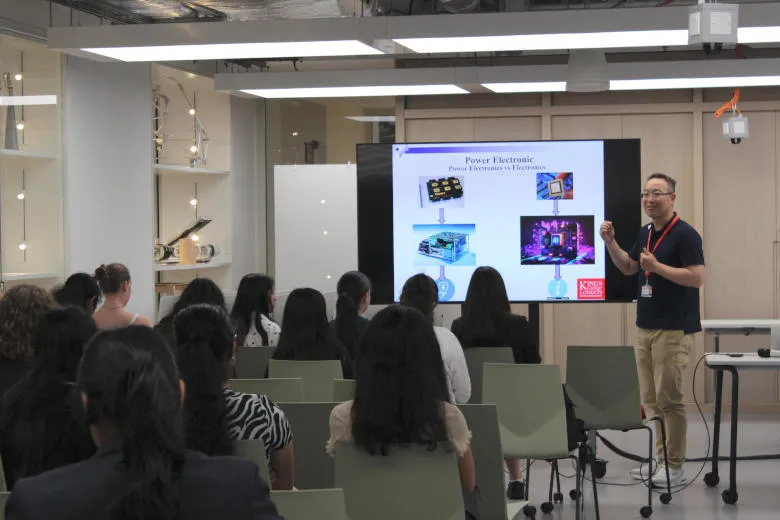 A man is talking about power electronics to a group of school girls