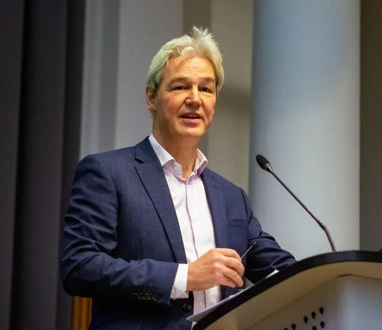 Michael Kolling stands at a lecturn, talking to an audience