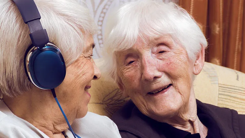 Older people with device and headphones