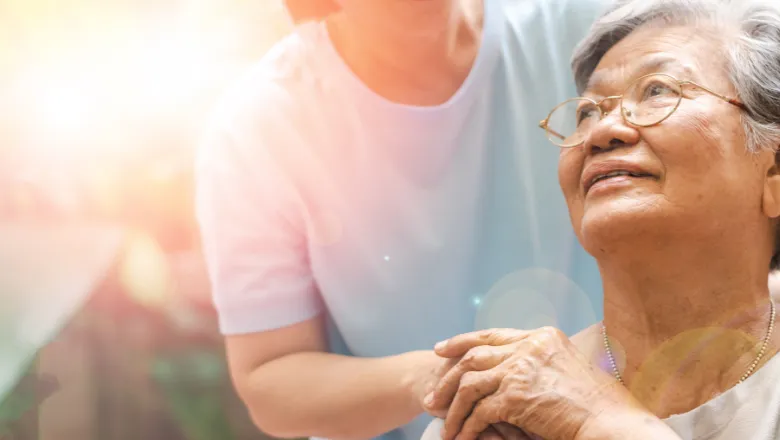 A smiling woman with glasses being comforted by another woman