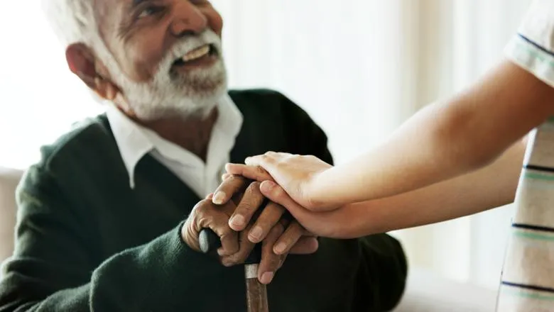 A man with a walking stick smiling