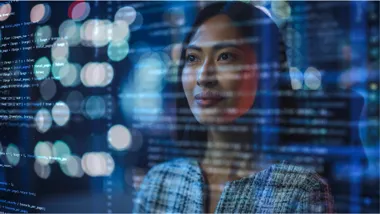 Portrait of Asian Female Startup Digital Entrepreneur Working on Computer, Line of Code Projected on Her Face and Reflecting by Gorodenkoff