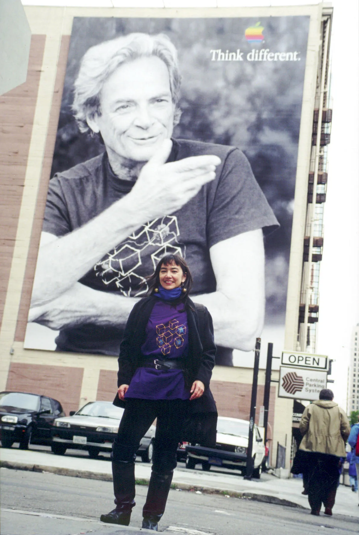 Tamiko Thiel in front of an Apple Computer “Think Different" poster featuring Richard Feynman, wearing the CM-1 t-shirt.