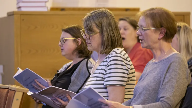 women singing in a choir like setting