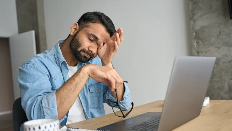 Man tired in front of a laptop 