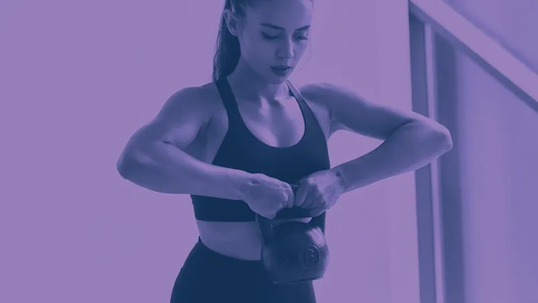 A woman holding a Kettlebell