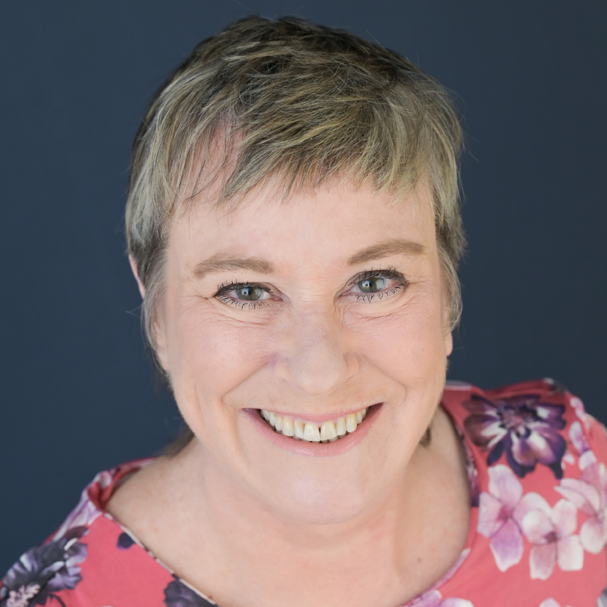 Dr Maitland smiles warmly in a pink floral top