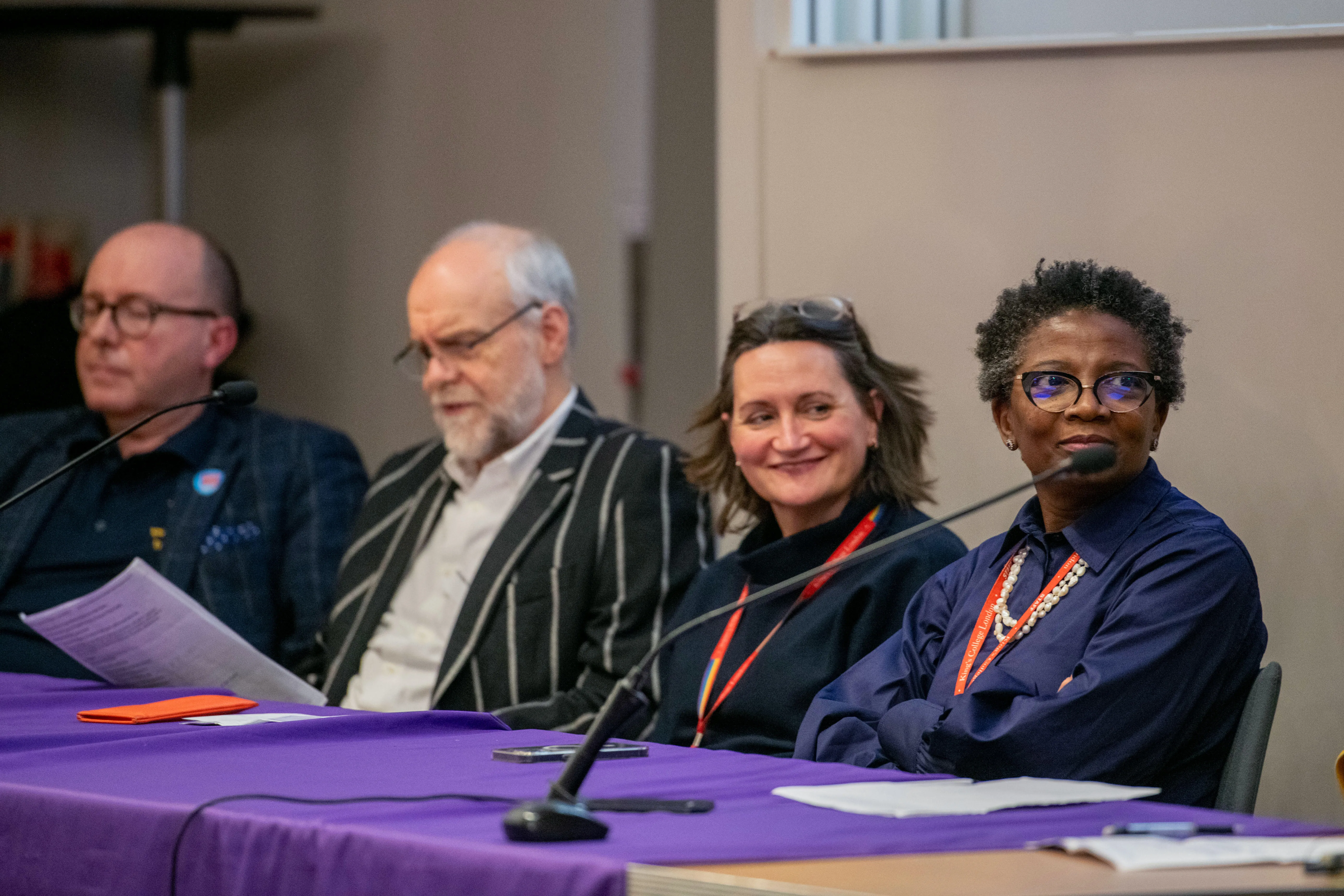 Panel of experts sit at a table during a discussion.