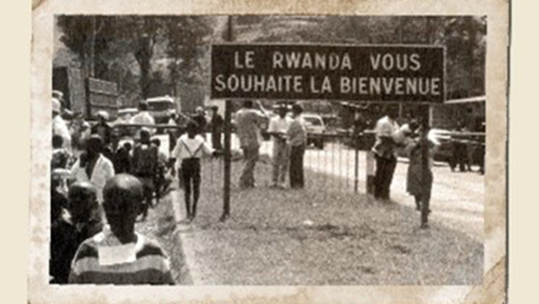 A black and white photograph of a group of people in Rwanda with  a sign reading Welcome to Rwanda