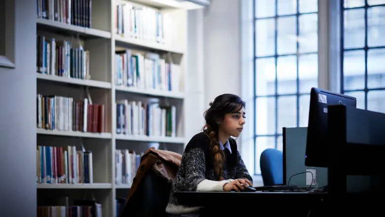 south-asian girl in Maughan Library studying at a computer