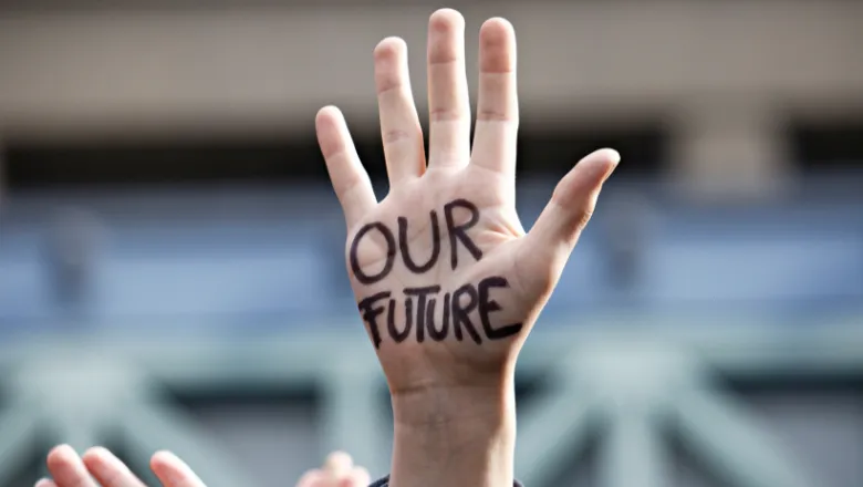 hand in air with 'our future' written on palm