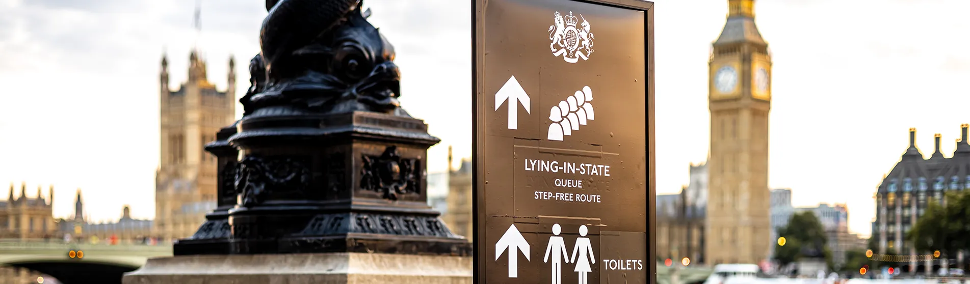 Sign for the Queen's lying in state queue with the Houses of Parliament in the background