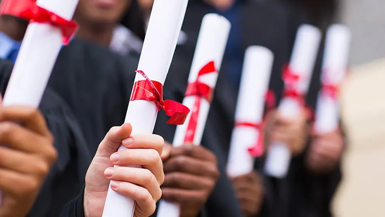 Graduates holding diplomas