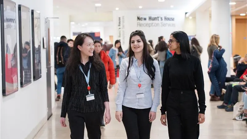 Three students are walking down a hall together