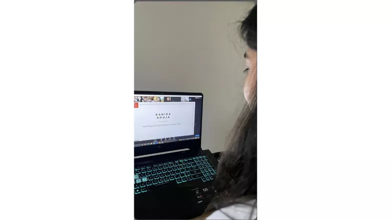 A student watches a virtual graduation ceremony on a laptop