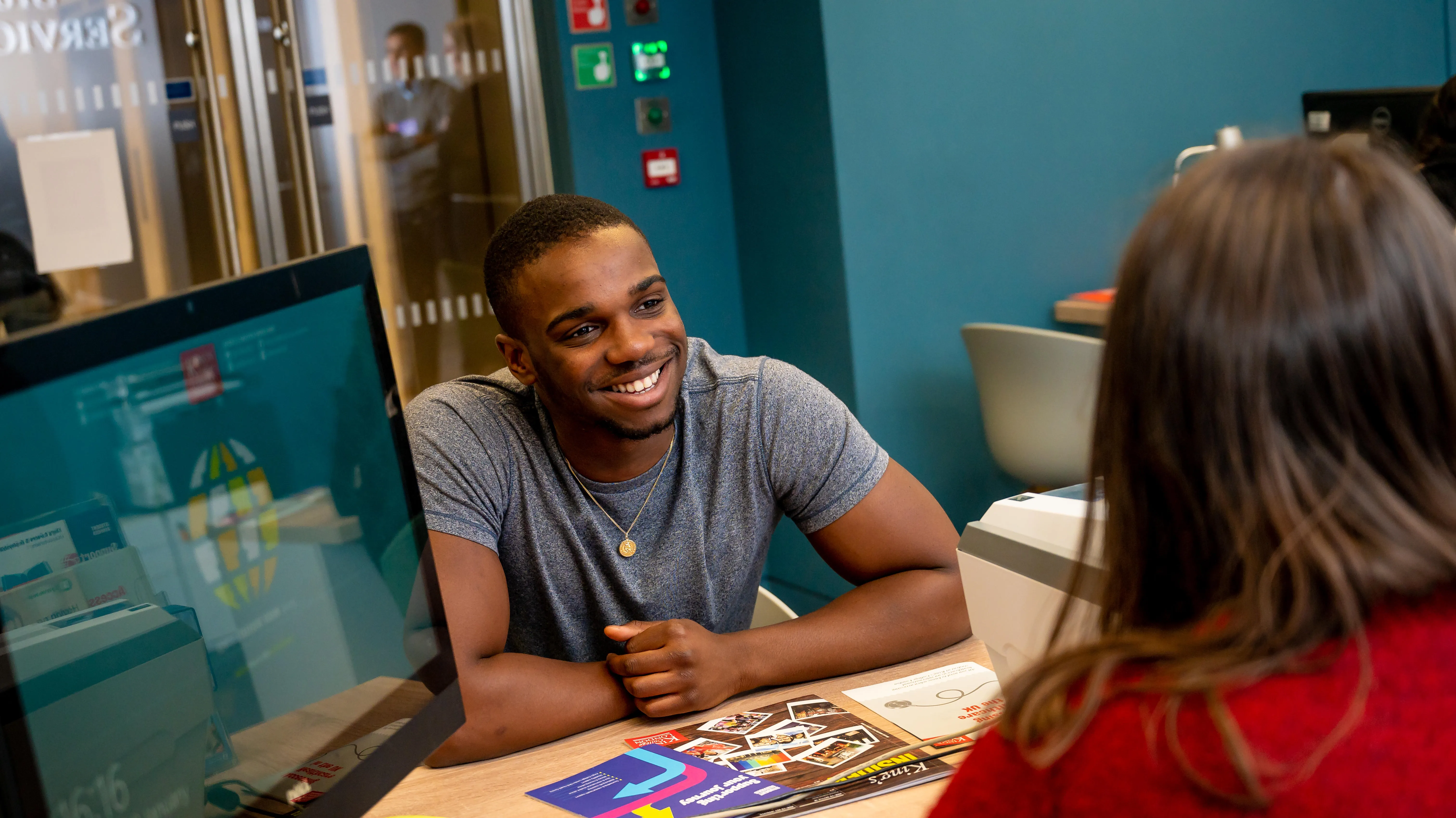 Student at a desk talking to an adviser.